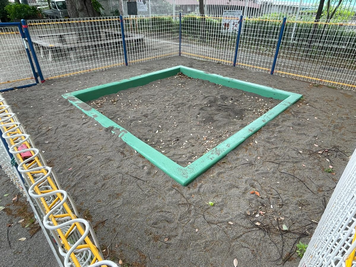 川岸公園 金属フェンスに囲まれた緑枠の砂場