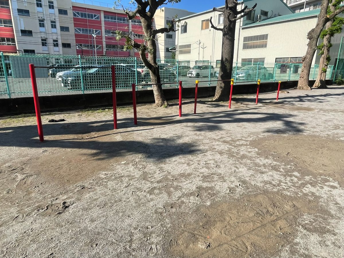 本町4丁目児童遊園地の鉄棒。赤いポールの複数段鉄棒が並ぶ