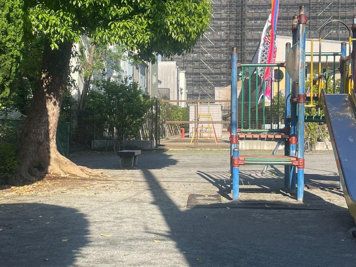 喜沢南2丁目児童遊園地の木陰エリア。大きな木の下にベンチが置かれた落ち着いた空間